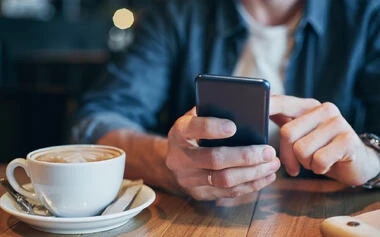 スマートフォンを見つめ思案する男性